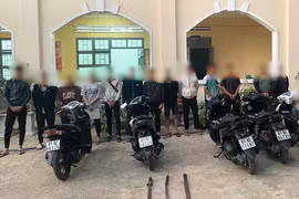 13 thanh-thiếu niên cùng tang vật là xe máy và dao tự chế tại cơ quan Công an. Ảnh: L.V.N