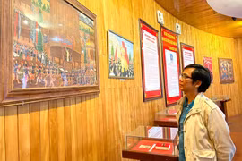 Tiến sĩ Lưu Hồng Sơn bên một bức tranh của họa sĩ Xu Man tại Bảo tàng tỉnh. Ảnh: P.D