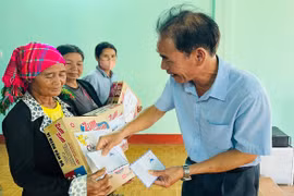 Bà Rơ Lan Kiơng (bìa trái, làng Queng Mép, xã Dun) nhận quà của Hội Nạn nhân chất độc da cam/dioxin xã. Ảnh: Đ.Y