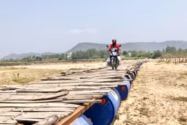 Người dân xã Chư Gu lưu thông qua cầu tạm. Ảnh: L.N