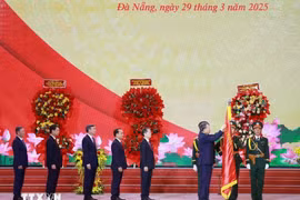 Tổng Bí thư Tô Lâm gắn Huân chương Lao động hạng Nhất lên Cờ truyền thống của Thành phố Đà Nẵng. (Ảnh: Thống Nhất/TTXVN)