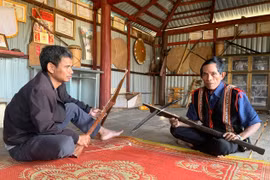 Già làng Đônh (bìa phải) giới thiệu về chiếc nỏ của người Bahnar. Ảnh: R.H