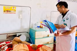 Bác sĩ Nguyễn Quang Khôi (Khoa Ngoại tổng hợp, Bệnh viện Nhi tỉnh) thăm hỏi một trường hợp bị thương do tai nạn pháo nổ. Ảnh: N.N