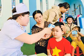 Nhân viên y tế thực hiện khám sàng lọc trước khi tiêm vắc xin phòng sởi cho trẻ em trên địa bàn tỉnh. Ảnh: N.N