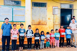 Chủ tịch Ủy ban MTTQ Việt Nam tỉnh Trần Minh Sơn (bìa trái) trao học bổng cho các em học sinh có hoàn cảnh khó khăn của làng Ar Tơ Măn (xã Đê Ar). Ảnh: Minh Hà