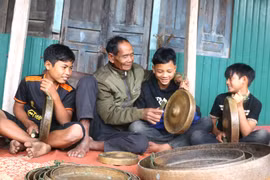Già làng Đinh Đuk (làng Tờ Nùng 1, xã Ya Ma) ân cần hướng dẫn các em nhỏ cách diễn tấu cồng chiêng. Ảnh: N.M