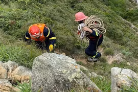 Cảnh sát đu dây đưa thi thể nạn nhân lên khỏi vách núi ở Nhơn Lý