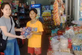 Chị Lê Thị Thảo trao đồ dùng học tập cho học sinh Jrai có hoàn cảnh khó khăn trên địa bàn. Ảnh: K.H