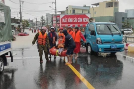 Lực lượng Công an đưa người dân vùng ngập ở phường Quy Nhơn Bắc về nơi an toàn.