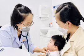 Bác sĩ khám sàng lọc sức khỏe trước khi tiêm chủng cho trẻ. Ảnh: N.N