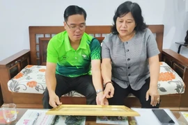 Chị Đinh Ly An giới thiệu những kỷ vật của cha-phi công Đinh Văn Đưới. Ảnh: N.A.M