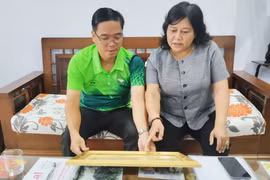 Chị Đinh Ly An giới thiệu những kỷ vật của cha-phi công Đinh Văn Đưới. Ảnh: N.A.M