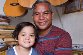 bé H'Thương được anh Ploi nhận nuôi cùng nhiều đứa trẻ mồ côi khác, mang đến cho các con hơi ấm của gia đình JPG