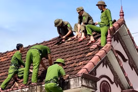 Công an xã Kbang hỗ trợ người dân sửa chữa nhà ở.