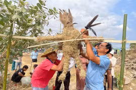 Ông Rmah Khiêm (bên phải) cùng người dân thôn Sô Ma Hang A làm hình nộm chuẩn bị cho lễ cúng bến nước. Ảnh: Vũ Chi