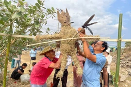 Ông Rmah Khiêm (bên phải) cùng người dân thôn Sô Ma Hang A làm hình nộm chuẩn bị cho lễ cúng bến nước. Ảnh: Vũ Chi