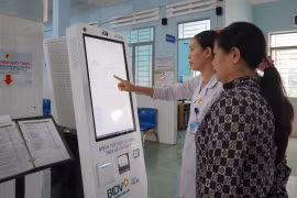 Nhân viên Bệnh viện Y học cổ truyền và Phục hồi chức năng Pleiku hướng dẫn người dân sử dụng kiosk y tế thông minh để đăng ký khám bệnh. Ảnh: Sơn Ca