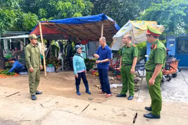 Ông Trần Minh Toàn, Phó Chủ tịch UBND xã Vân Canh (giữa) thuyết phục một tiểu thương quay trở lại chợ Vân Canh mới buôn bán. 