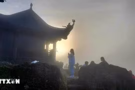 Phật tử "vượt sương, đi xuyên màn đêm" để đón bình minh trên chùa Đồng, nơi đỉnh thiêng Yên Tử, sáng sớm 5/10. (Ảnh: Thanh Vân/TTXVN)