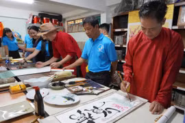 Họa sĩ-nghệ sĩ thư pháp La Hán Vinh trình diễn thư pháp tại buổi giao lưu. Ảnh: Sơn Ca