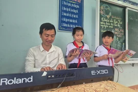 Thầy Trần Trọng Nghĩa trong giờ dạy nhạc tại điểm trường Cồn Chim. Ảnh: Ái Trinh