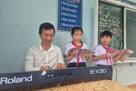 Thầy Trần Trọng Nghĩa trong giờ dạy nhạc tại điểm trường Cồn Chim. Ảnh: Ái Trinh