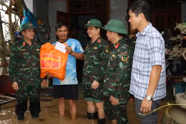 Thượng tướng Trương Thiên Tô (bìa trái) thăm, tặng quà người dân vùng lũ ở phường Quy Nhơn Đông.