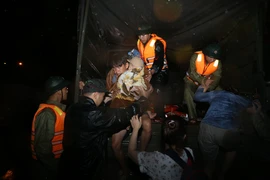 Các lực lượng ứng cứu xuyên đêm để đưa người dân bị ngập lụt sâu ở phường Quy Nhơn Bắc đến nơi an toàn.