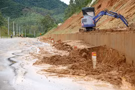Lực lượng chức năng huy động phương tiện khắc phục sạt lở trên tuyến đường tránh phía Nam thị trấn Phú Phong.