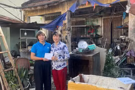 Phó Chủ tịch Thường trực Liên đoàn Lao động tỉnh Gia Lai Nguyễn Thị Bích Thủy (trái) động viên, trao hỗ trợ cho bà Hồ Thị Thanh Tuyền có nhà bị hư hỏng nặng. Ảnh: H.P