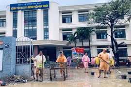 Cán bộ Phòng Cảnh sát giao thông Công an TP. Hồ Chí Minh dọn dẹp bùn đất tại Bệnh viện Lao và Bệnh phổi Quy Nhơn.