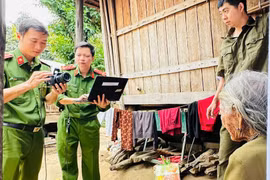 Cán bộ Công an xã Kbang chụp ảnh Căn cước cho cụ Đinh Qiu (ở làng Nak) ngay tại bậc thềm nhà sàn.