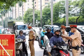 Cảnh sát Giao thông kiểm tra nồng độ cồn với người tham gia giao thông. Ảnh: Phạm Kiên/TTXVN