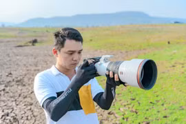 Phạm Công Quý say mê với chiếc máy ảnh trên một chuyến tác nghiệp. Ảnh: NVCC