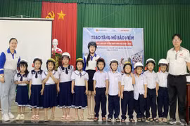 Học sinh khối lớp 1 Trường Tiểu học số 1 Phù Mỹ được tặng mũ bảo hiểm đạt chuẩn.