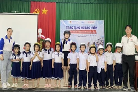 Học sinh khối lớp 1 Trường Tiểu học số 1 Phù Mỹ được tặng mũ bảo hiểm đạt chuẩn.