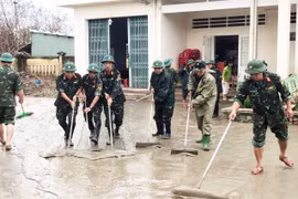 Bộ đội dầm mình trong bùn non, giúp người dân dọn dẹp và tái thiết nhà cửa, trường học sau trận lũ lịch sử.
