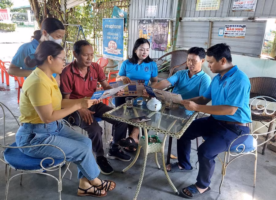 Nhân viên BHXH huyện Đak Pơ tuyên truyền, vận động người dân tham gia BHXH tự nguyện, BHYT hộ gia đình (ảnh BHXH Gia Lai cung cấp).