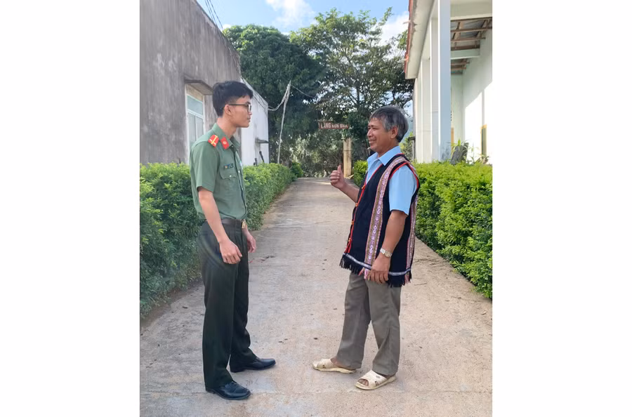 Ông Đinh Trinh (bìa phải) trao đổi về tình hình an ninh trật tự trong làng với cán bộ Công an. Ảnh: R.H