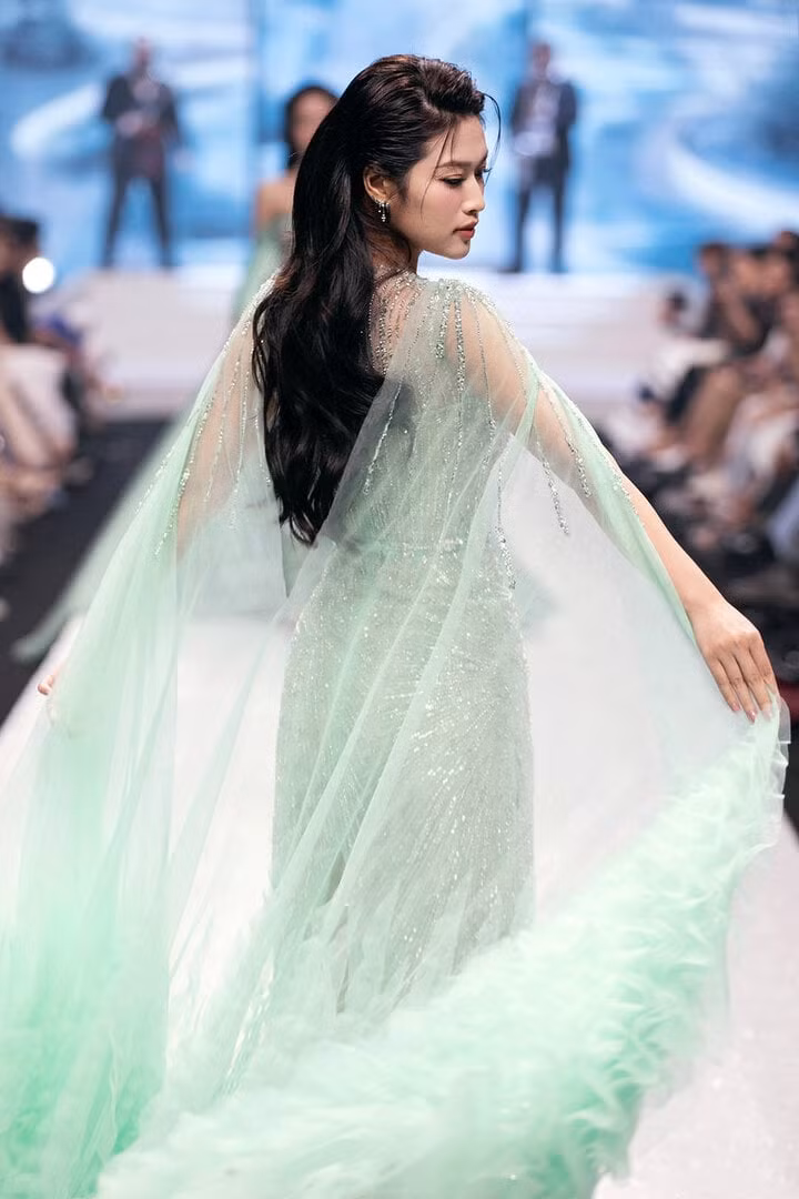 Hoa hậu Thiên Ân mở màn bộ sưu tập "Sương mai" của NTK Lê Ngọc Lâm. Nàng hậu gây chú ý với nhan sắc lộng lẫy.