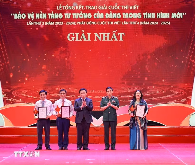 Đại tướng Phan Văn Giang, Ủy viên Bộ Chính trị, Bộ trưởng Bộ Quốc phòng và ông Nguyễn Xuân Thắng, Ủy viên Bộ Chính trị, Chủ tịch Hội đồng Lý luận Trung ương, Giám đốc Học viện Chính trị Quốc gia Hồ Chí Minh trao giải cho các tác giả, nhóm tác giả đoạt giải Nhất cuộc thi viết " Bảo vệ nền tảng tư tưởng của Đảng trong tình hình mới." (Ảnh: Thanh Tùng/TTXVN)