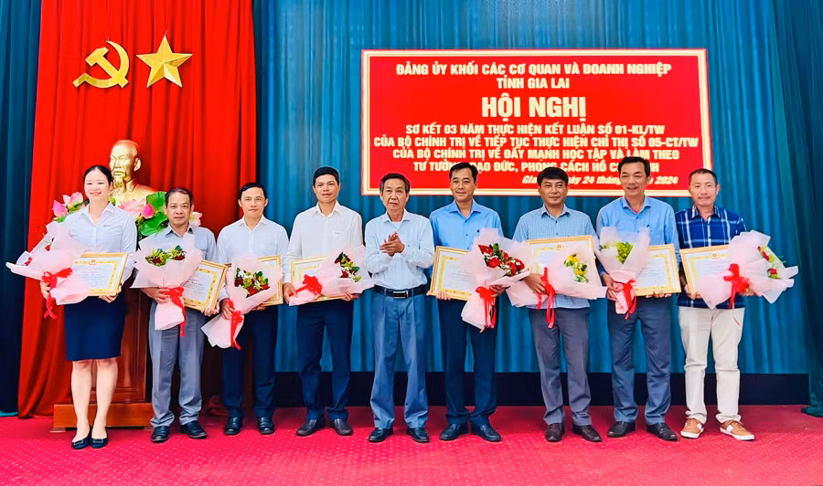 Phó Bí thư Đảng ủy Khối các Cơ quan và Doanh nghiệp tỉnh Huỳnh Tấn Đoan tặng giấy khen cho các cá nhân có thành tích trong học tập và làm theo tư tưởng, đạo đức, phong cách Hồ Chí Minh. Ảnh: PHAN LÀI