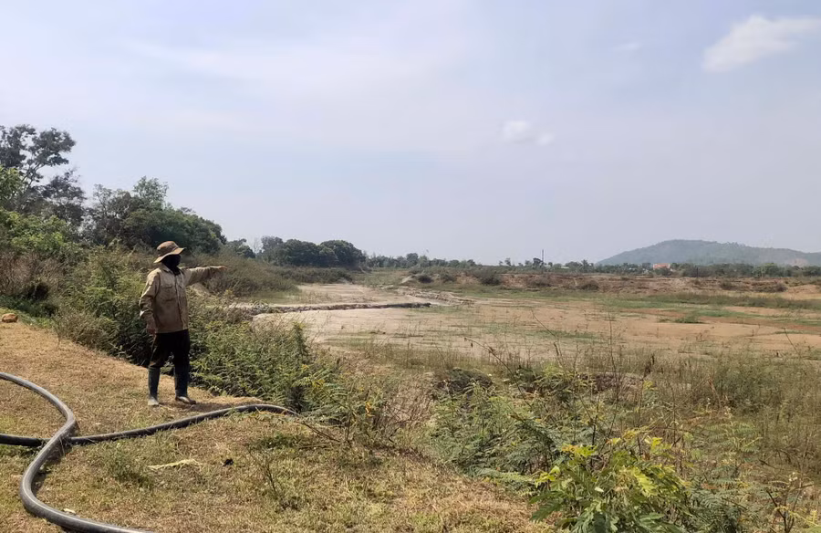 Ông Phạm Đắc Kiểm-thôn Tây Hồ (xã Bầu Cạn, huyện Chư Prông) chỉ tay về hồ thủy lợi 14B giờ cạn khô đáy. Ảnh: L.N