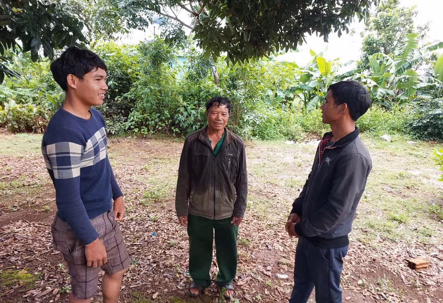 Ông Rlan Pit đứng giữa) tuyên truyền, trao đổi công việc cùng những người trẻ. Ảnh: Nguyễn Hồng