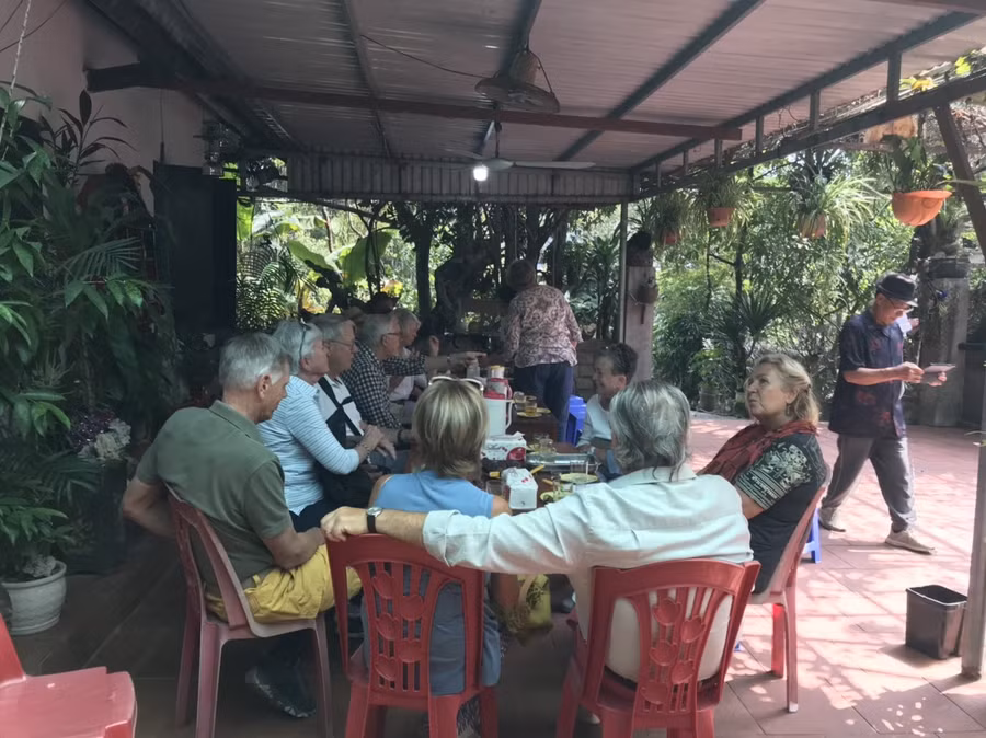 Du khách ngồi thưởng thức món khoai lang luộc tại một nhà dân ở huyện Vân Đồn sáng 20-2. Ảnh: Nguyễn Hùng