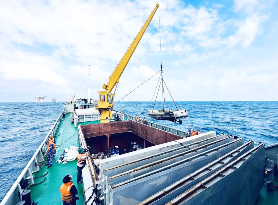 Các chiến sĩ triển khai công tác cẩu xuồng. Ảnh: ALĂNG NGƯỚC