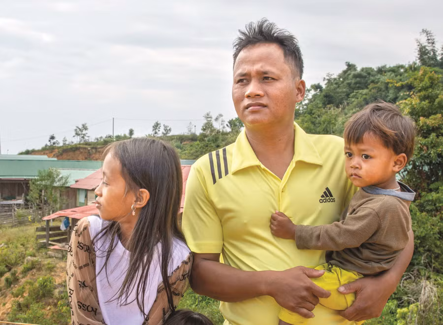 Anh Pơ Loong Non chăm sóc con ở nhà để vợ đi làm xa. Ảnh: VĂN CHƯƠNG