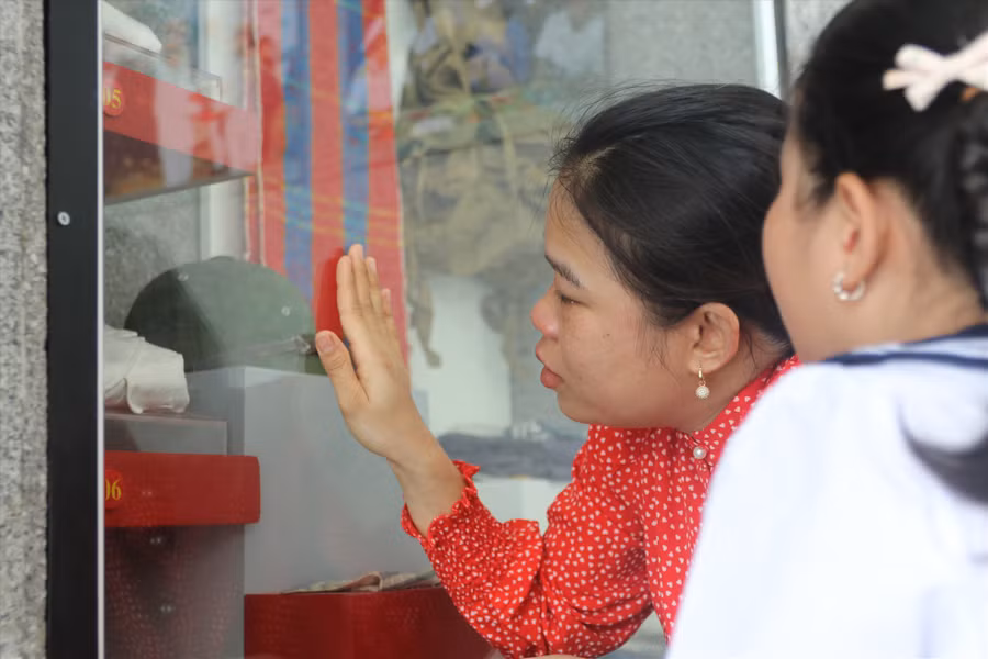 Con gái liệt sĩ Phan Huy Sơn (Nghệ An) xúc động trước kỷ vật của bố được lưu giữ tại bảo tàng Gạc Ma. Ảnh: Phương Linh
