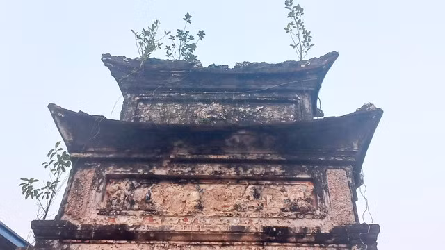 Cổng phụ nghi môn cỏ cây mọc rễ càng làm cho công trình nhuốm màu sắc của thời gian