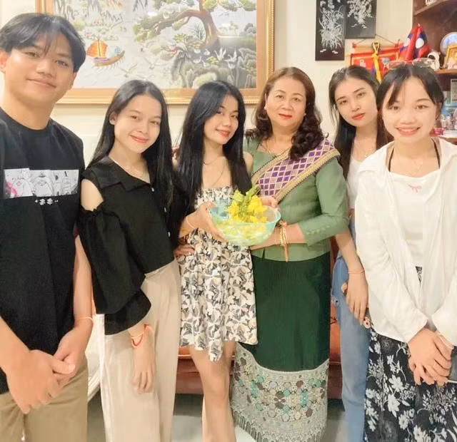 Bà Hằng trong trang phục truyền thống của Lào chụp ảnh cùng các con